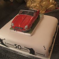 E Type Jag E Type Jaguar (red) Hand crafted using gum paste. The car sits on a 12 inch cake. I made the car so it can be removed and kept as a memento...