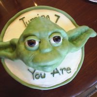 Yoda Birthday Cake Chocolate cake with white buttercream filling and frosting. Yoda shaped with rice crispy treats and covered in modeling chocolate with gum...
