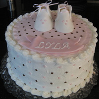 Lyla's Baby Shower This is a buttercream frosting with fondant booties, blanket and dots on the sides.