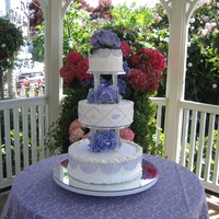 Laura's Cake The bride and groom actually designed this cake. The frosting is buttercream with purple buttercream details. The flowers are real. There&#...