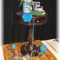 Life Size Mahagony Accent Table Cake.... The top of the table is hummingbird cake, the base is lemon pound cake. The center pedastol is pvc pipe wrapped in chocolate clay with the...