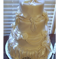 Ivory Fondant Covered Wedding Cake with draping and roses dusted with pearl luster dust.