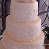 Jenna's Cake This is just a simple fondant covered three tier stacked cake. I sprayed gold dust lightly to get the champagne color the bride requested...