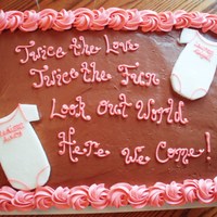 Twin Baby Shower Cake Chocolate butter cream with fondant onesi's. The shower colors were brown and pink.