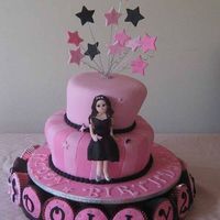 Dollys 21St Birthday two teir in wonky style with a third teir of cupcakes. First time trying stripes. Model hand made from fondant