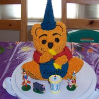 Winnie The Pooh My youngest's first birthday cake. Used the stand up bear pan. The hat is a frosted sugar cone and the honey is piping gel.