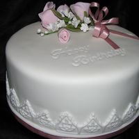 80Th Birthday a rich fruit cake covered in RTR, Happy birthday embossed into the icing and finished with a spray of roses.