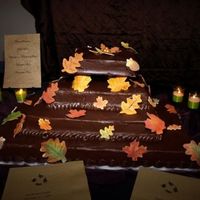 Autumn Wedding Cake 4 layers#1 bananas foster#2 pumpkin spice#3 chocolate#4 red velvetAll iced in chocolate ganache with gum paste accents.