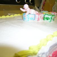 Close Up Of Blocks And Baby Wilton's Fondant molded Baby and blocks are covering 1" squares of marble cake.