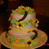 Wilton_001.jpg my practice mini cake of swriled peach and light blue butter cream with flowers and chocolate branches.
