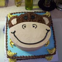 Frontal Face View Of Monkey All White Cake, with buttercream, chocolate and white, and the bananas are fondant, first time with bananas, and carving a cake before