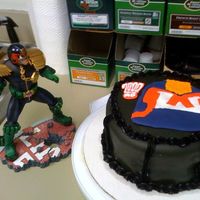 Judge Dredd Color flo picture with chocolate cake; covered in black fondant with black buttercream decoration. Inside is plain white buttercream.