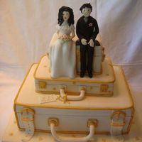 Golden Suitcases Only middle suitcase has a cake inside. Bottom and top are fake. Bride wanted to keep topper with figures forever! She was very excided...