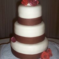 Simple Wedding Cake The brown ribbons are fondant, the orange roses are gumpaste. It matched the theme very well, I was a little scared because of the colors,...