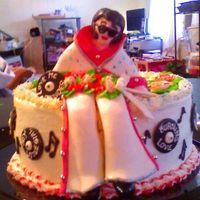 Elvis Figure is fondant with buttercream rose bouquet. Records are fondant with buttercream. Cake is buttercream with buttercream two-toned roses...
