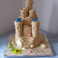 Sand Castle Cake This is my first wedding cake. The cakes are (from top to bottom) Red Velvet, French Vanilla and Dark Chocolate. They are covered in MMF...
