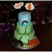 Dinosaur Birthday Cake 4th birthday cake for my son. IMBC with fondant accents and RKT dinosaurs covered in fondant and hand-painted. Inspired largely by jaklotz1...