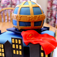 Batman And Superman Chocolate ball cake on white cake 14-inch square base. All covered in fondant. Half of cake was Superman themed, the other Batman. City...