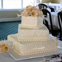 Calla Lilies Bottom tier butter pecan with praline filling, middle is french vanilla with cherry buttercream filling, top is french vanilla with...