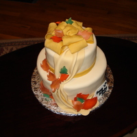 70Th Birthday Fondant covered cake with draping and decorated with fall colored leaves. Topper was a floppy bow. The birthday "girl" did not...