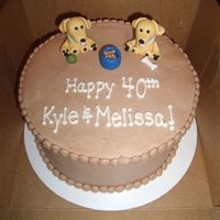 Yellow Lab Birthday Cake Fondant yellow labs, dog food bowl, bone and tennis ball on top of chocolate cake.