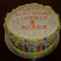 Double Daisy Birthday 10" french vanilla cake with buttercream dream icing, gumpaste daisies, and fondant stripes.