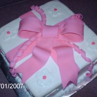 Course 3 Package Cake This is an 8" white cake with amaretto buttercream filling covered in white chocolate rolled fondant. The bow is made of fondant.