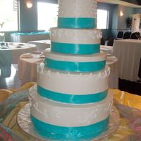 Ivory Wedding Cake Ivory buttercream with white piping. Bride chose teal ribbon for the bottom of each tier. Each cake was a different flavor with different...