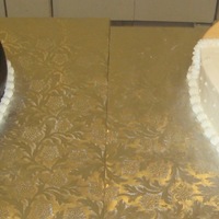 Bride/groom Heart shaped cakes. Grooms cake is covered in dark chocolate fondant. Bride cake is buttercream with pearl dragees.