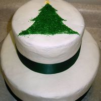 Christmas Tree 2-tier chocolate cake with mocha filling. Buttercream with green satin ribbon around base. Coarse green sugar in the shape of Christmas...