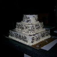 Picture_006.jpg My very first tiered cake.I was practicing for a wedding cake i am doing in 2 weeks.Ignore the decorating i was just doodling to get the...