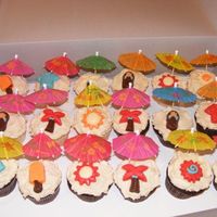 Beach Cupcakes 12 yellow and 12 chocolate with BC frosting with candy piece and paper umbrella.