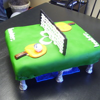 Ping-Pong Cake This was for a friends boss that loved ping-pong. The paddle and ball are made out of fondant. The net and logo is made out of color flow....