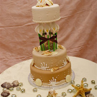 Beach Wedding With Calla Lilies 3 tiered cake with gumpaste calla lilies tied with a brown satin ribbon. WC fondant with WC shells and royal icing coral.