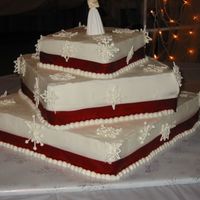 My_Snowflake2.jpg only my second wedding cake. the bride wanted snow flakeswith red ribbon around each tier.