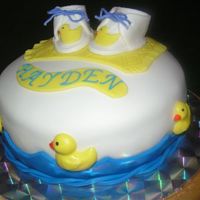 Baby Shower Cake Three layered chocolate cake with strawberry mousse filling, covered in buttercream icing and then MMF. Booties, duckies, waves and blanket...