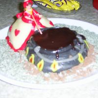 Pic_0014.jpg This is a woman who is stiring in a huge bowl of melted chocholat.. it's a marsipan cake. Both the voman anf the culdron.