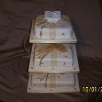 Ivory And Gold This cake is two fruit and one sponge with a parcel effect, the ribbon is organza with sugar hearts and diamante around the cakes and the...