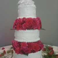 Locking Hearts Buttercream with fresh flowers. The topper was the bride's granparents anniversayr topper. So it was sentimental to the bride:)