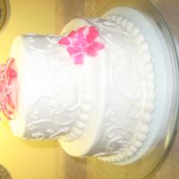 Sophisticated Pink! 6 &10 inch tiers for bridal shower. Yellow cake with cream cheese buttercream icing. Scrollwork on sides. Flowers are fondant painted...