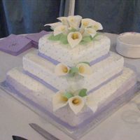 Calla Lilies This is a WASC cake filled with raspberry mousse and frosted with buttercream. The calla lilies and leaves are gumpaste.