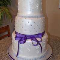 Starburst Wedding Cake 6,8,10" round covered with MMF, piped details and sprayed with Luster dust. The ribbon is real. Thanks for looking!