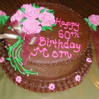 60Th Birthday Cake Cake is covered in chocolate buttercream icing with royal icing flowers. The bow/ribbon is stuck in the cake w/ a lollipop stick. It was...