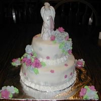 Julia's First Communion Cake This is a 2 tiered First Communion Cake. It is covered in fondant with fondant roses. The topper is ceramic. The borders and leaves are all...