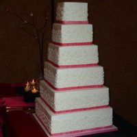 Square Cake With White Cut Out Flowers This was a six tiered square cake frosted in buttercream. The cut out flowers were fondant.