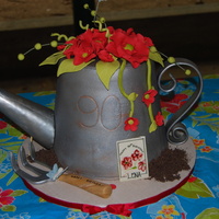 Watering Can cake carved from 3, 8" rounds. made for lady who loves to garden. covered in fondant and painted with silver and copper dust.