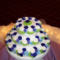 Purple Floral Wedding Cake Three tiered wedding cake, frosted with Bettercream, with purple buttercream roses, and other assorted petals.