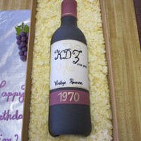 Wine Bottle Cake cake made for 40th birrthday party. wine bottle made from fondant by wrapping actual wine bottle half-way around with fondant, letting dry...