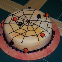 Spiders And Spider Web I cover the cake with orange marble fondant. Pipe on the web and made the spiders out M&M.