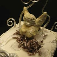 Angel Cake With Blown Pulled Sugar Pulled sugar flowers and vines with a white chocolate angel made from a custom chocolate / sugar mould.